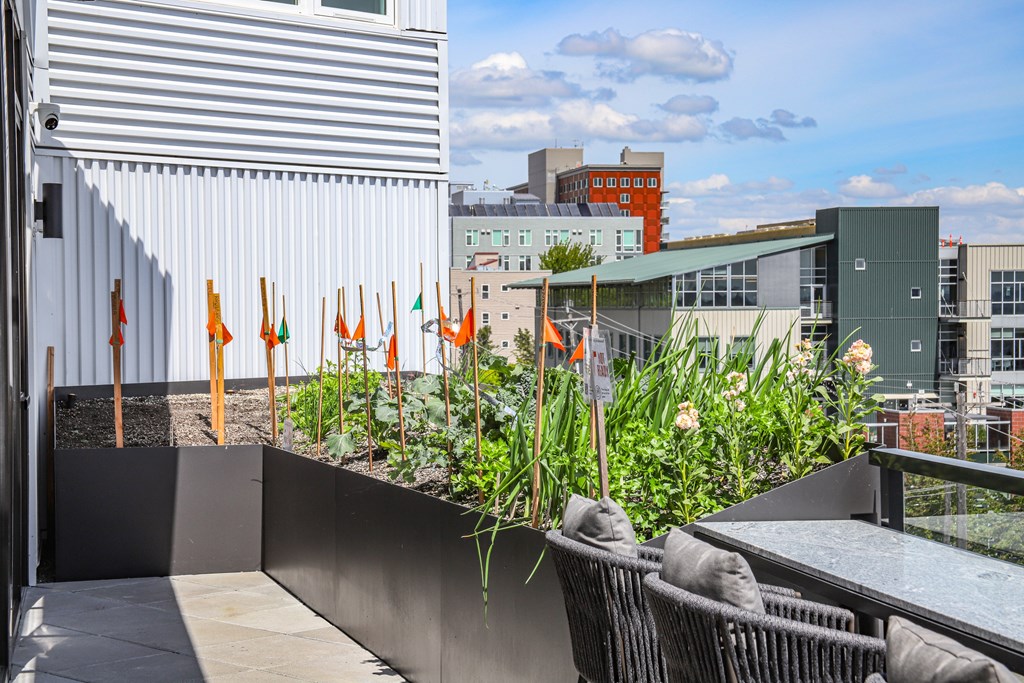 A patio with a table and chairs overlooking a cityscape.