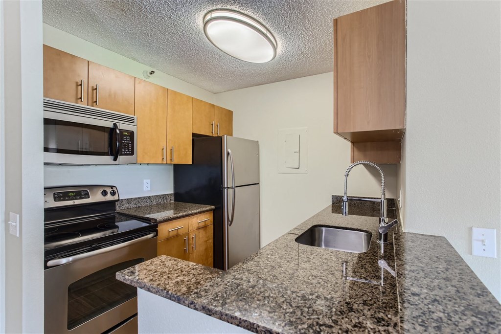 a kitchen with granite counter tops and stainless steel appliances