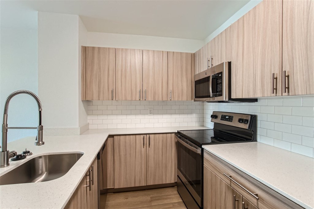 an empty kitchen with wooden cabinets and a sink