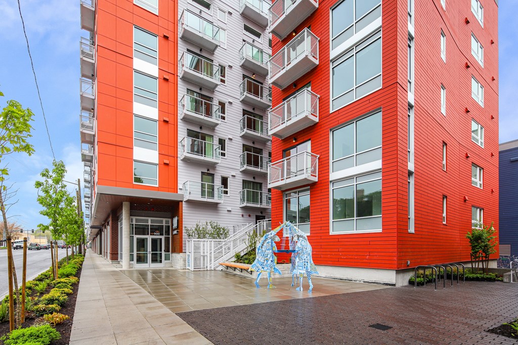 A red and white building with a sculpture in front.