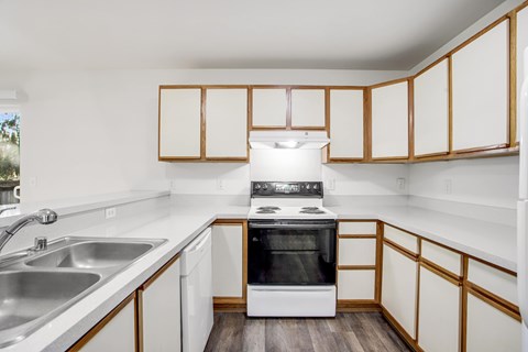 A kitchen with white cabinets and a black oven.