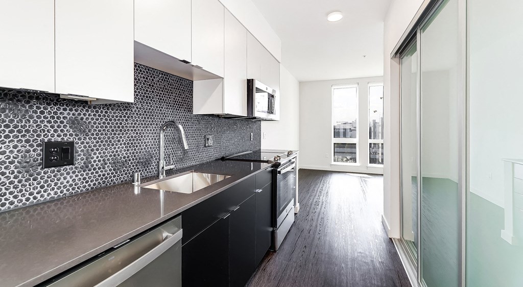 a black and white kitchen with a sink and a window