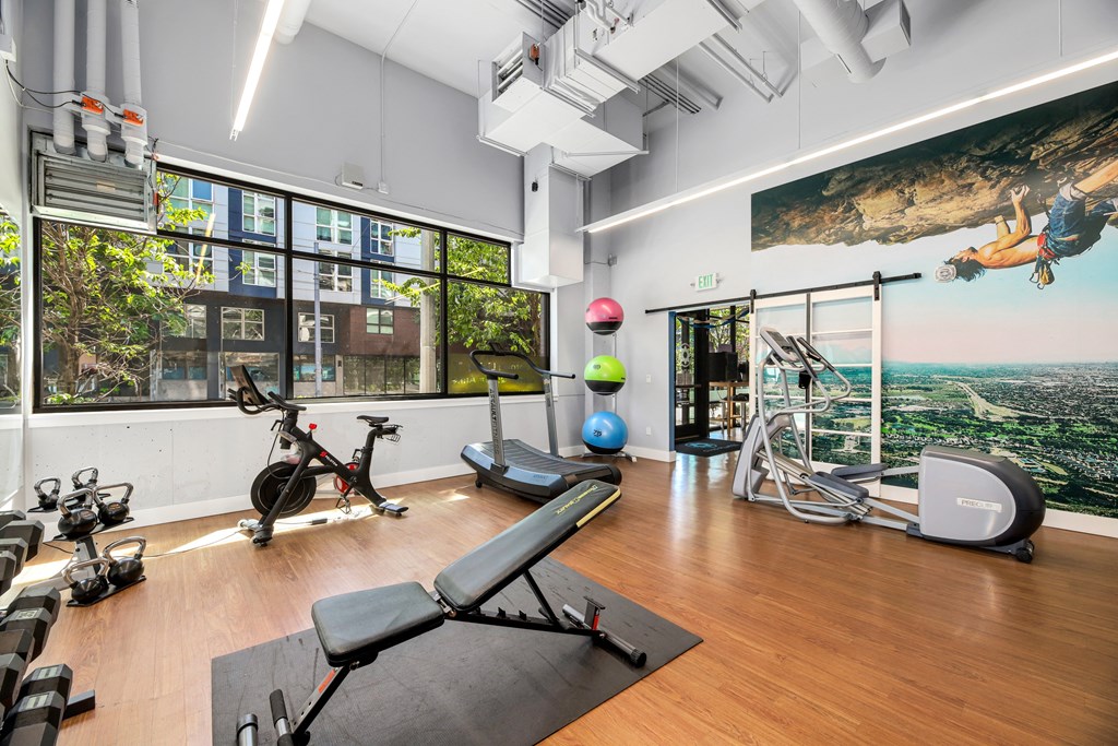 a workout room with yoga equipment and a large window with a view of the city