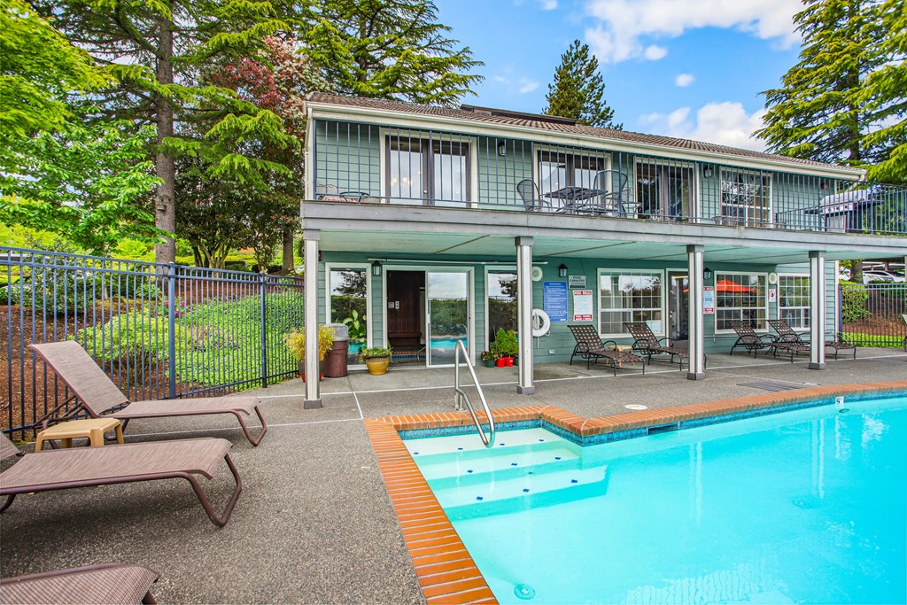 a house with a swimming pool and a patio with chairs