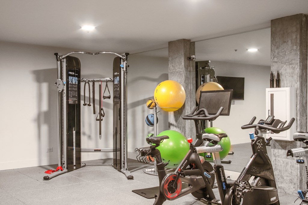 a home gym with exercise equipment and a yellow ball