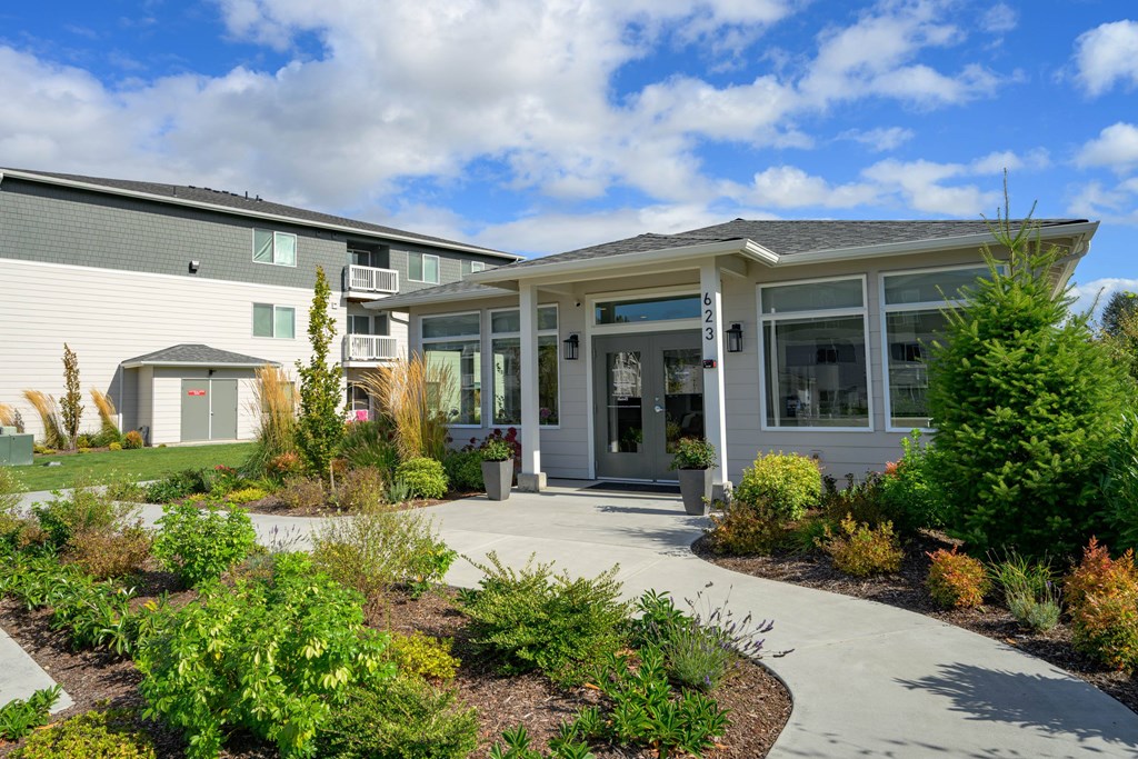 A modern building with a landscaped front yard.