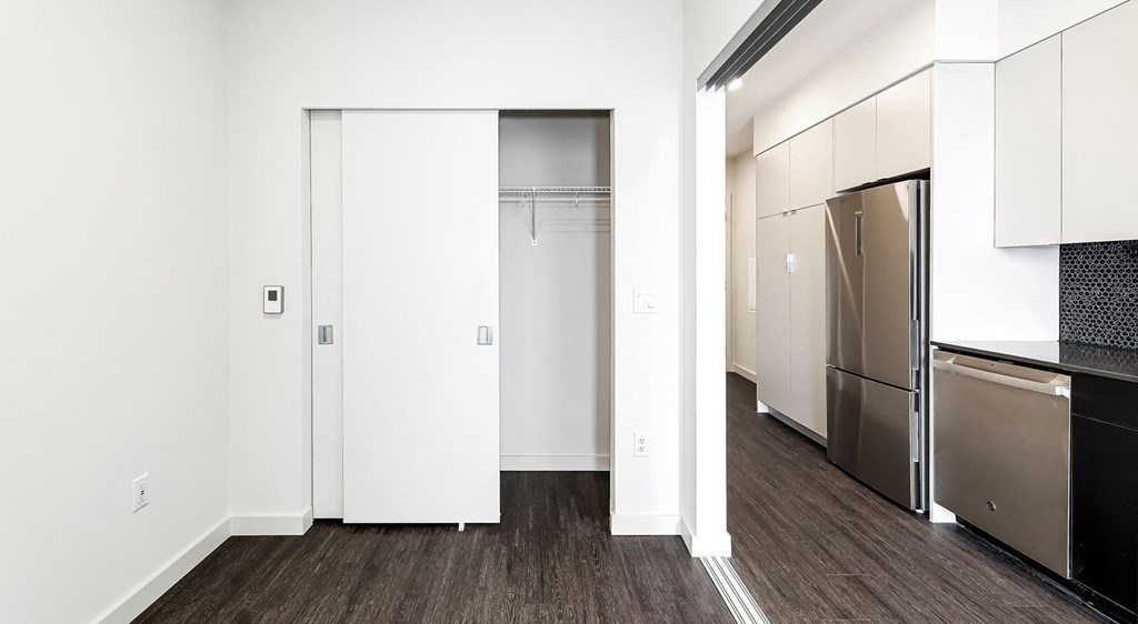 a renovated kitchen with white cabinets and a stainless steel refrigerator