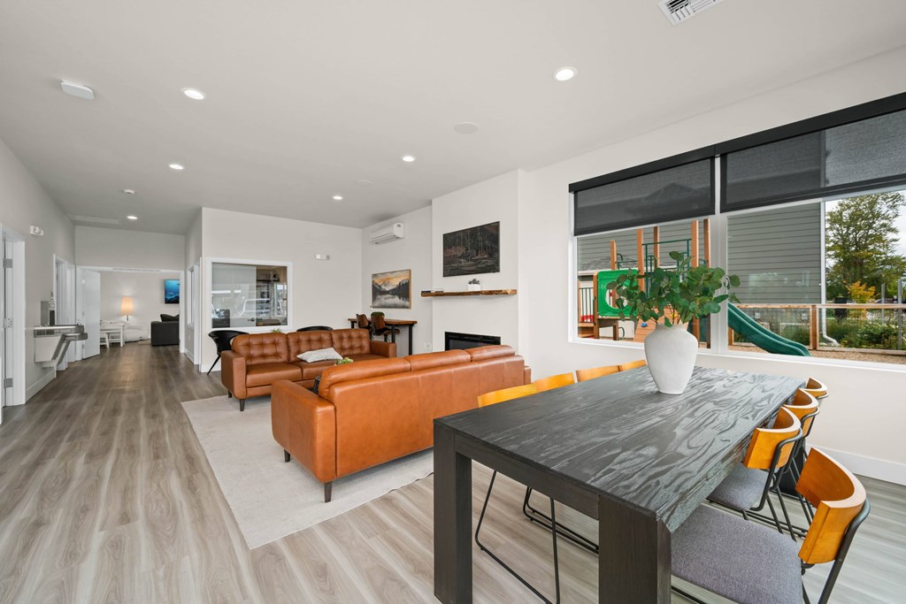 A modern living room with a long table and chairs.