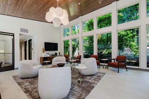 A modern living room with white furniture and a wooden ceiling.