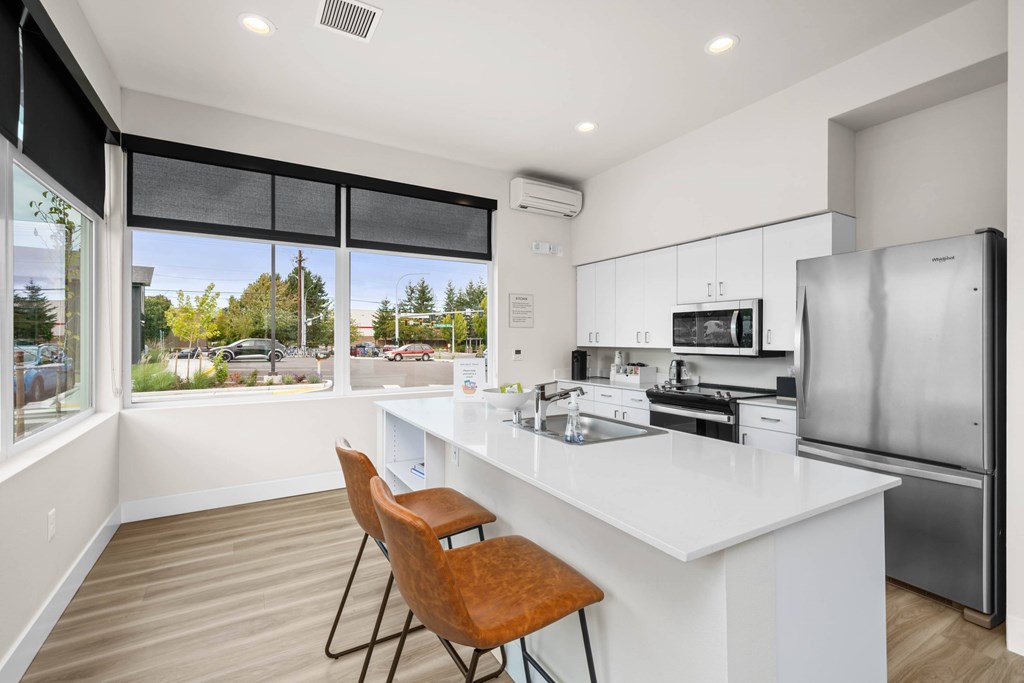 A modern kitchen with a white countertop and a refrigerator.