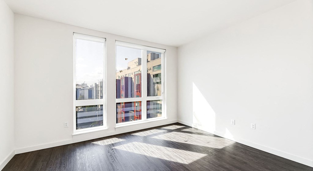 a living room with a large window and wood floors