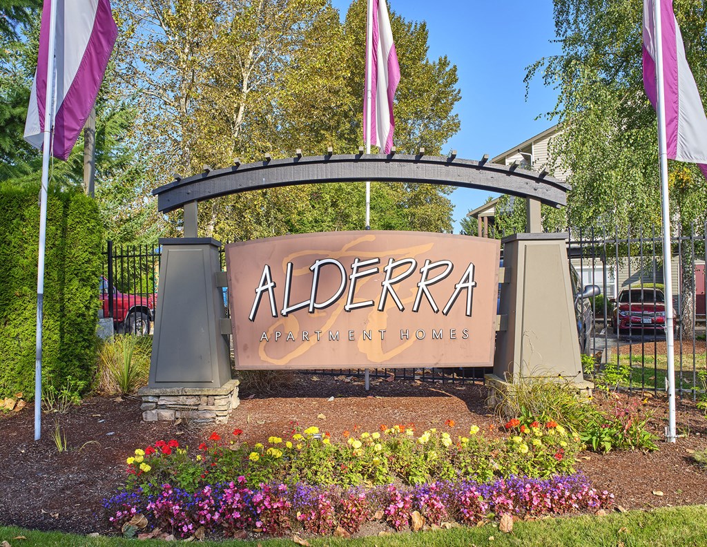 a sign for algera dentistry center in front of flowers