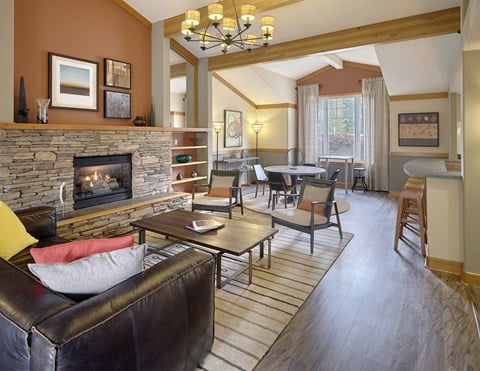 a living room with a fireplace and a table with chairs