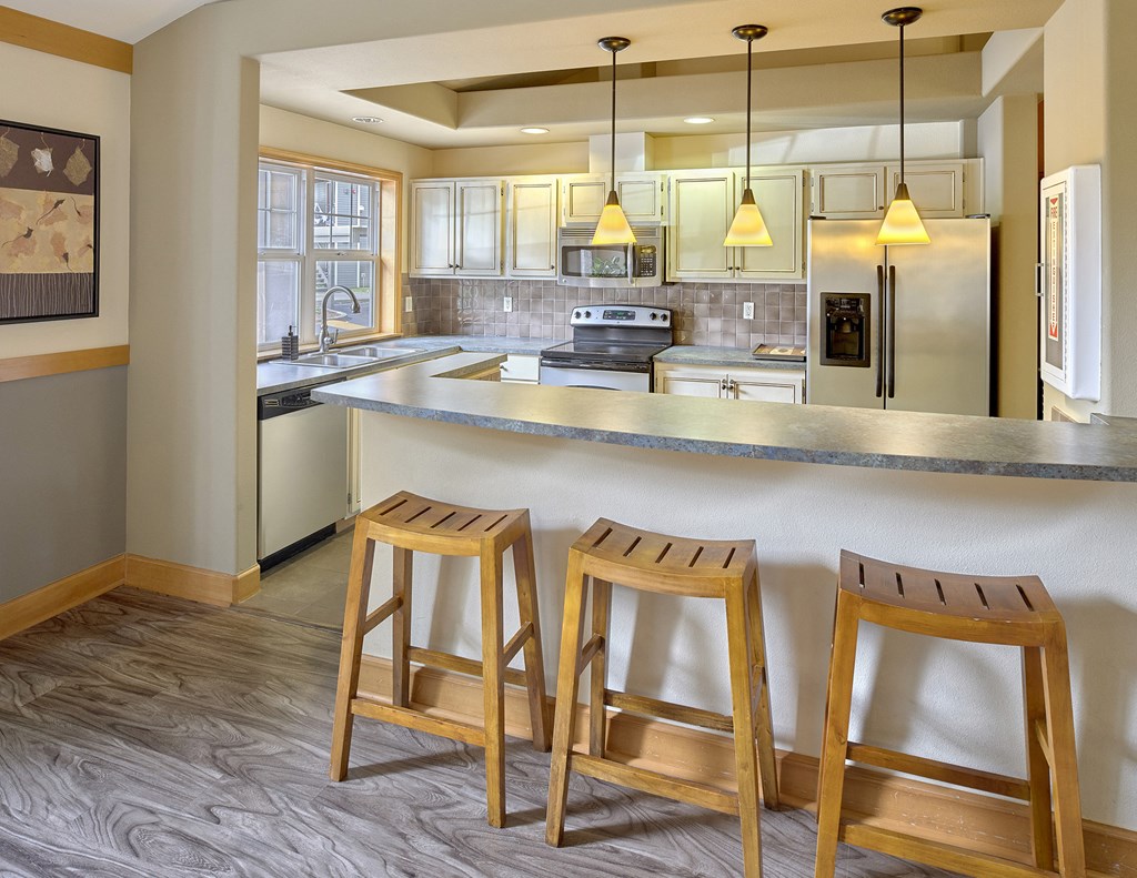 a kitchen with three stools in front of a counter top
