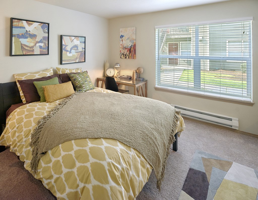 a bedroom with a large bed and a window