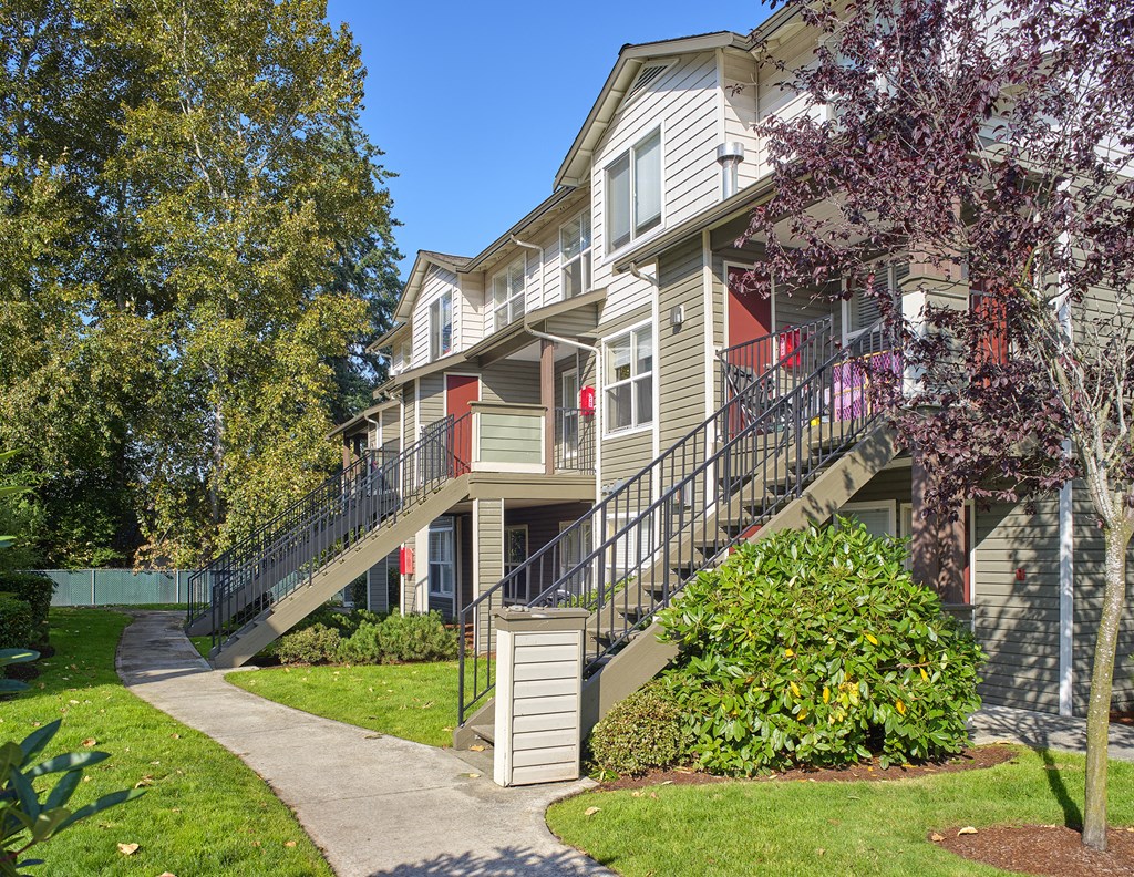 an exterior view of an apartment building with stairs and a sidewalk