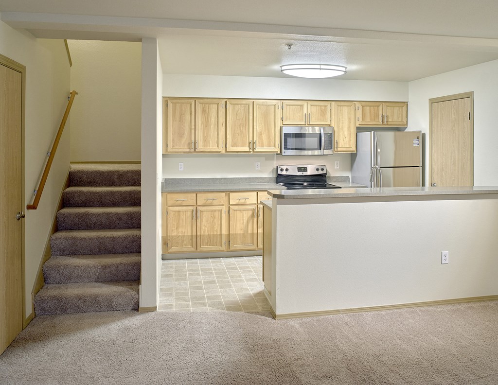 a view of a kitchen with a counter and stairs in a house