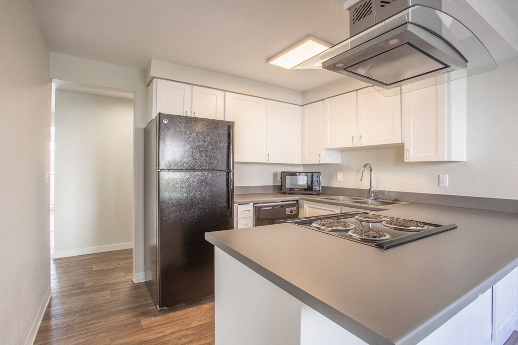 a kitchen with white cabinets and a stainless steel refrigerator