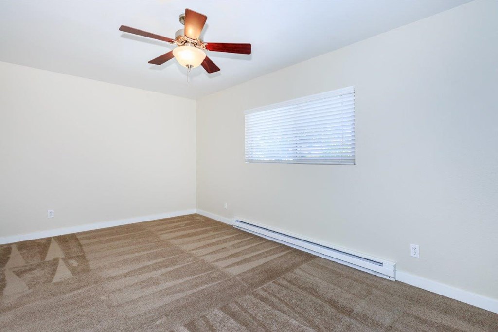 a living room with a ceiling fan and a window