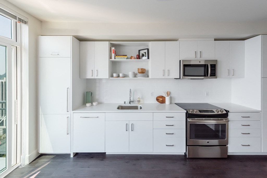 a kitchen with white cabinets and stainless steel appliances