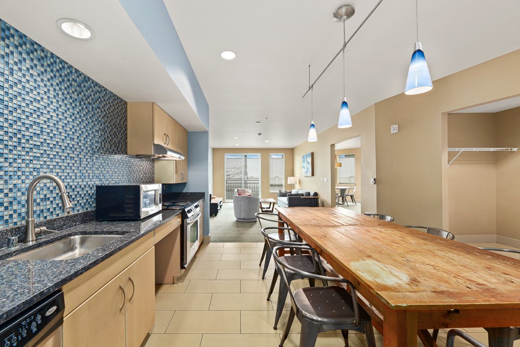 a kitchen with a long wooden table and a sink