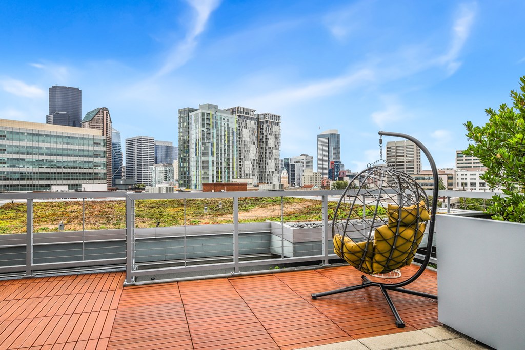 a roof terrace with a chair and a view of the city