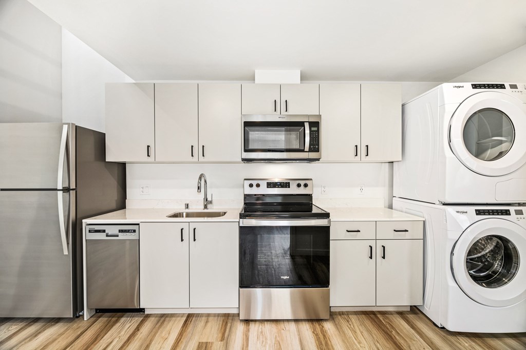 A modern kitchen with stainless steel appliances and white cabinets.