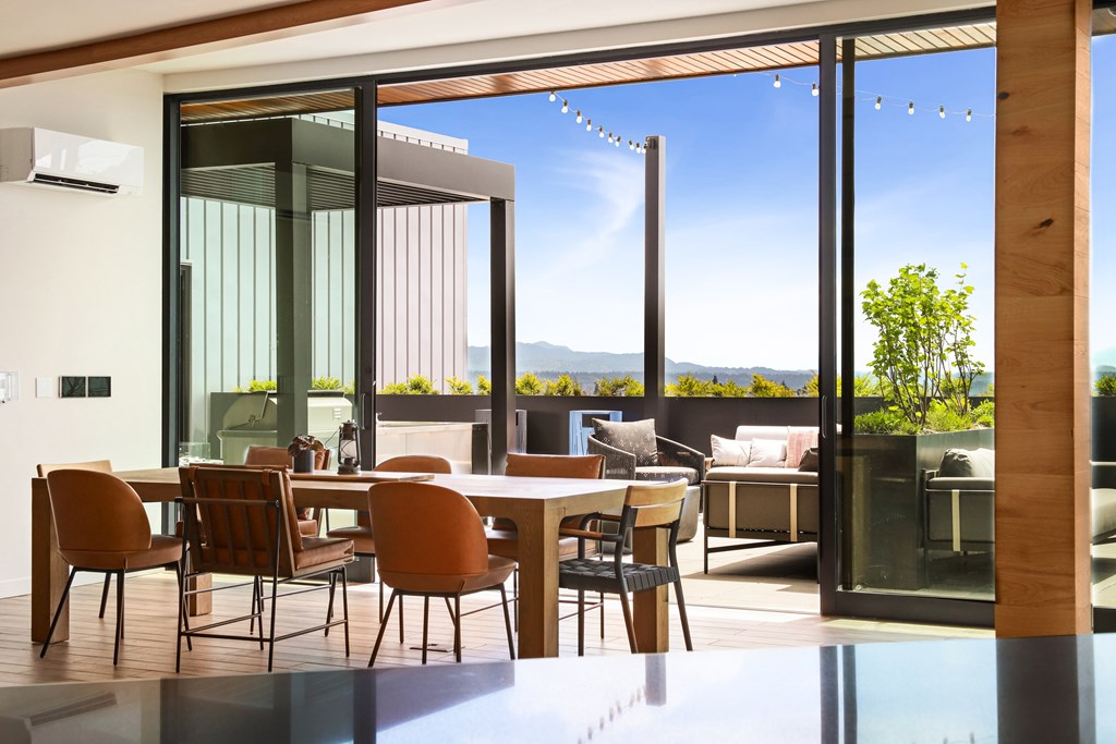 A modern dining room with a glass table and chairs.