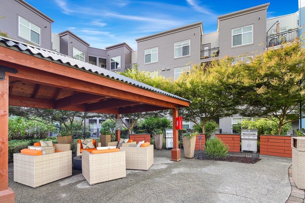 A patio area with a roof and several chairs and tables.