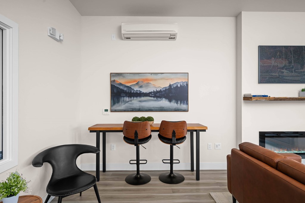 A living room with a painting on the wall and a fireplace.