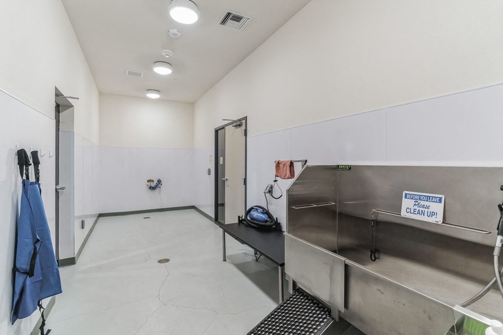 a laundry room with stainless steel appliances and a sink