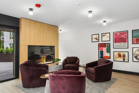 a living room with purple chairs and a fireplace