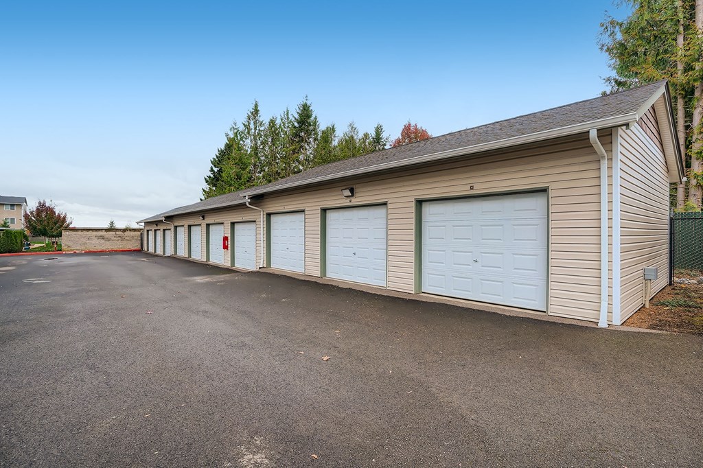 a long row of garages with white garage doors