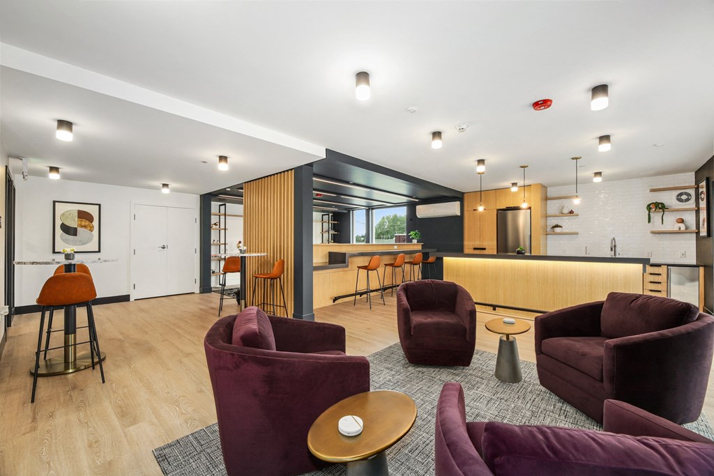 a living room with couches and chairs and a kitchen with a bar