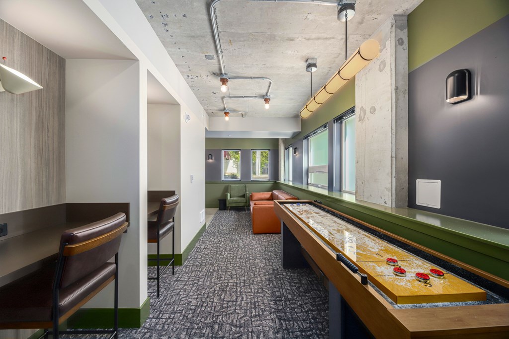 A room with a pool table and a bar area.