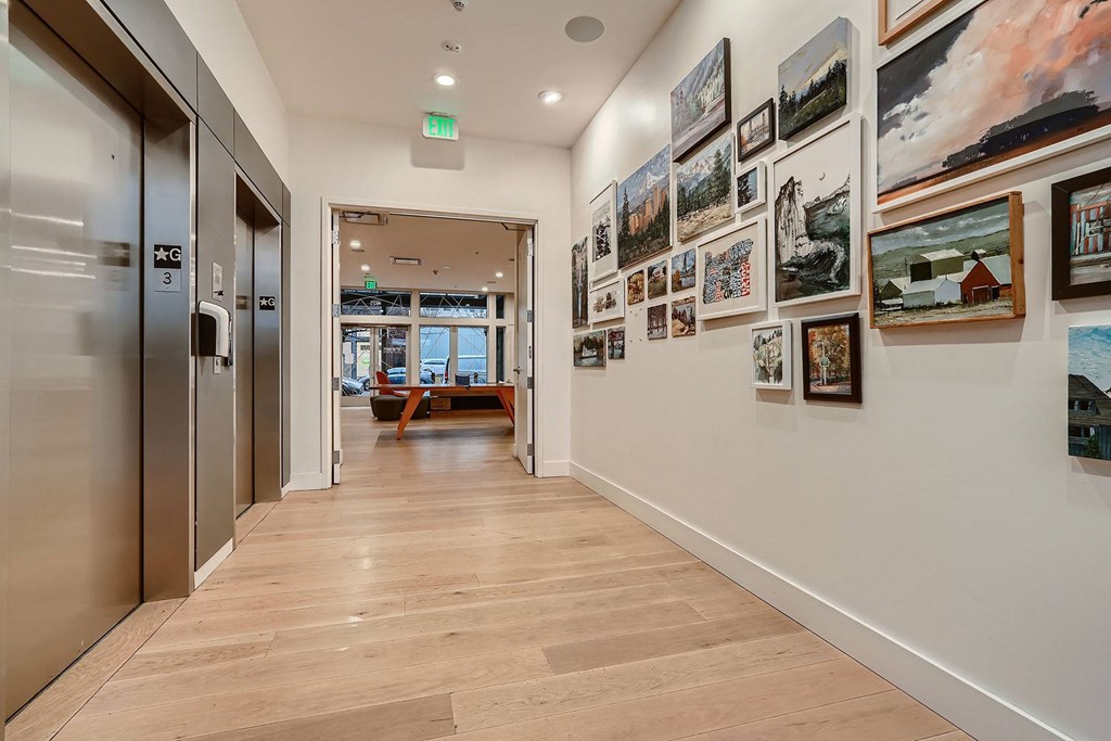a long hallway with pictures on the wall and a door