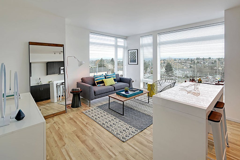 A living room with a grey couch and a white coffee table.