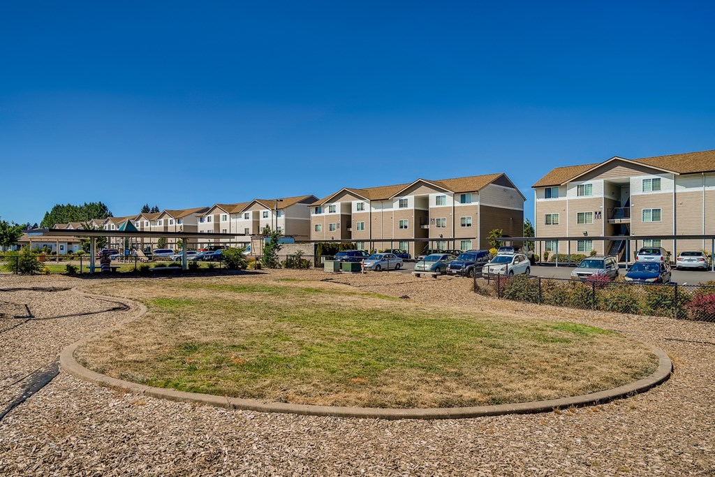 A residential area with apartment buildings and a grassy area in the foreground.