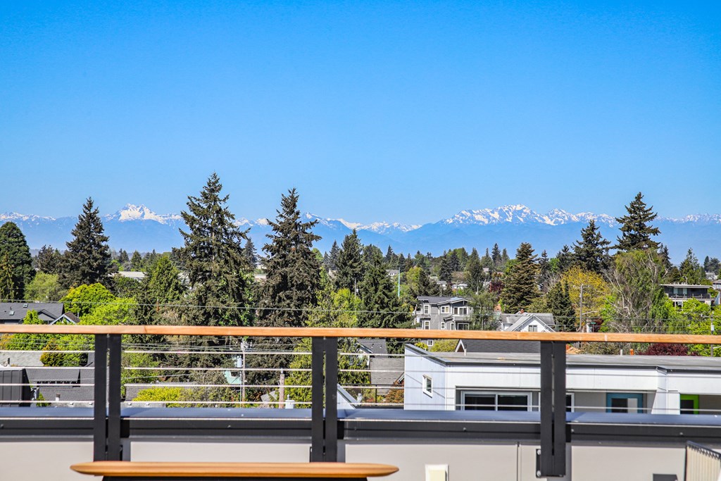 a view of the mountains from a balcony with a bench