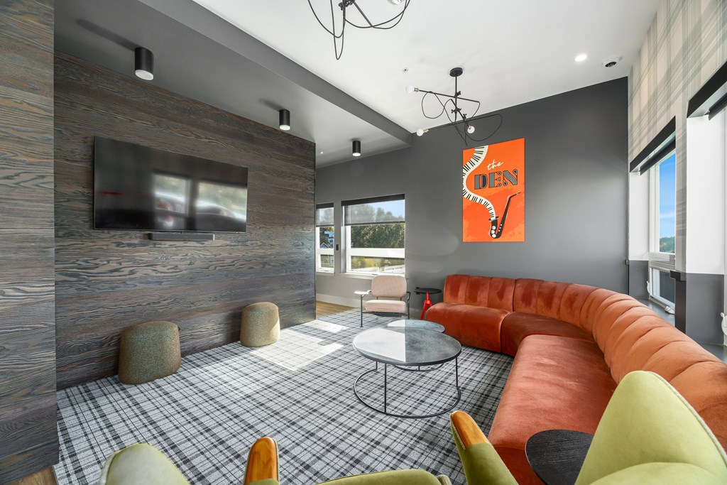 A modern living room with a grey and orange color scheme.