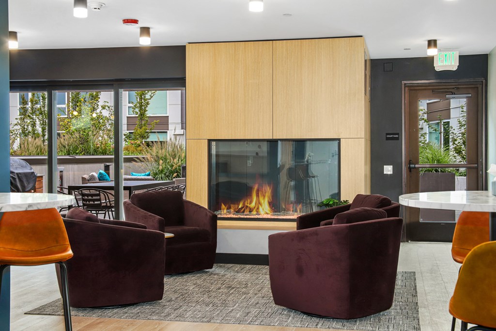 a living room with a fireplace and chairs