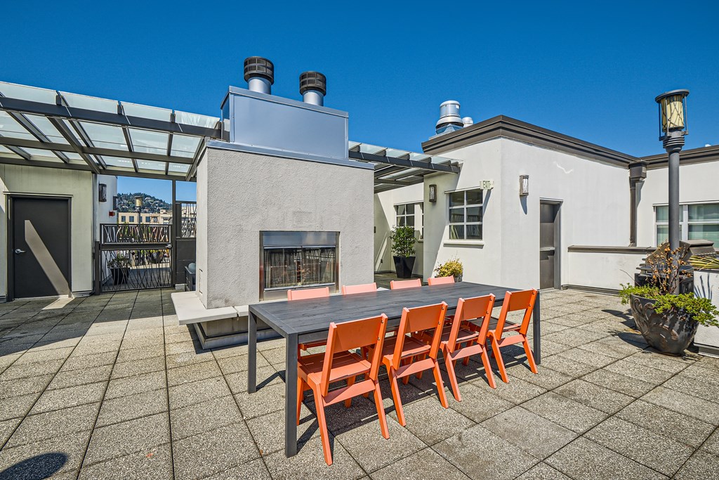 a dining table and chairs on a patio with a fireplace