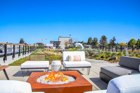 a patio with couches and a fire pit