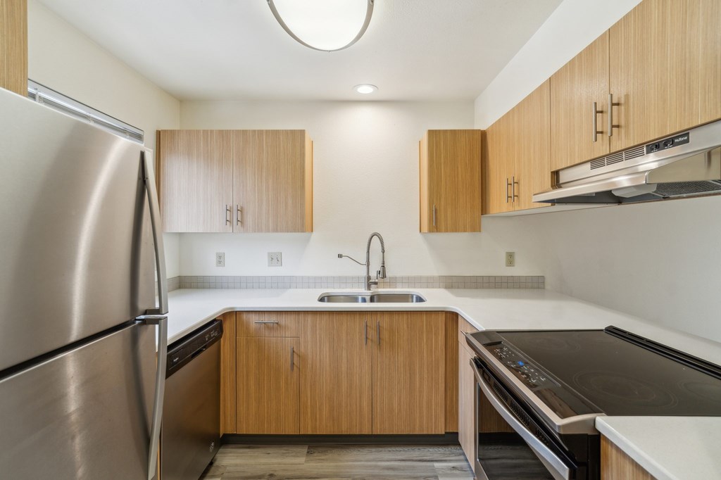 A modern kitchen with wooden cabinets and stainless steel appliances.