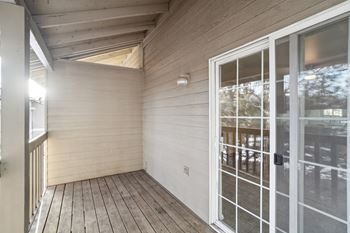 A balcony with a glass door and a window.