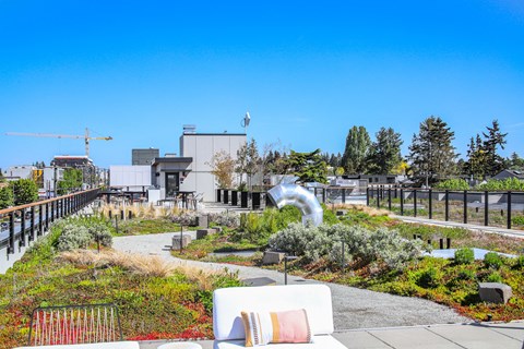a patio with a couch and a garden with a fountain