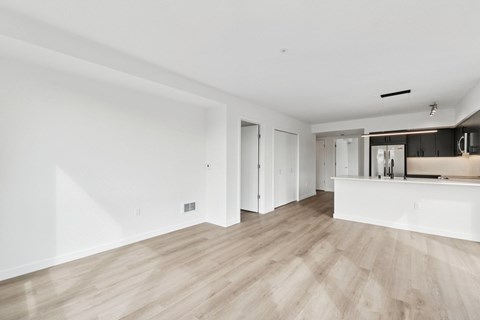 A spacious room with wooden flooring and white walls.