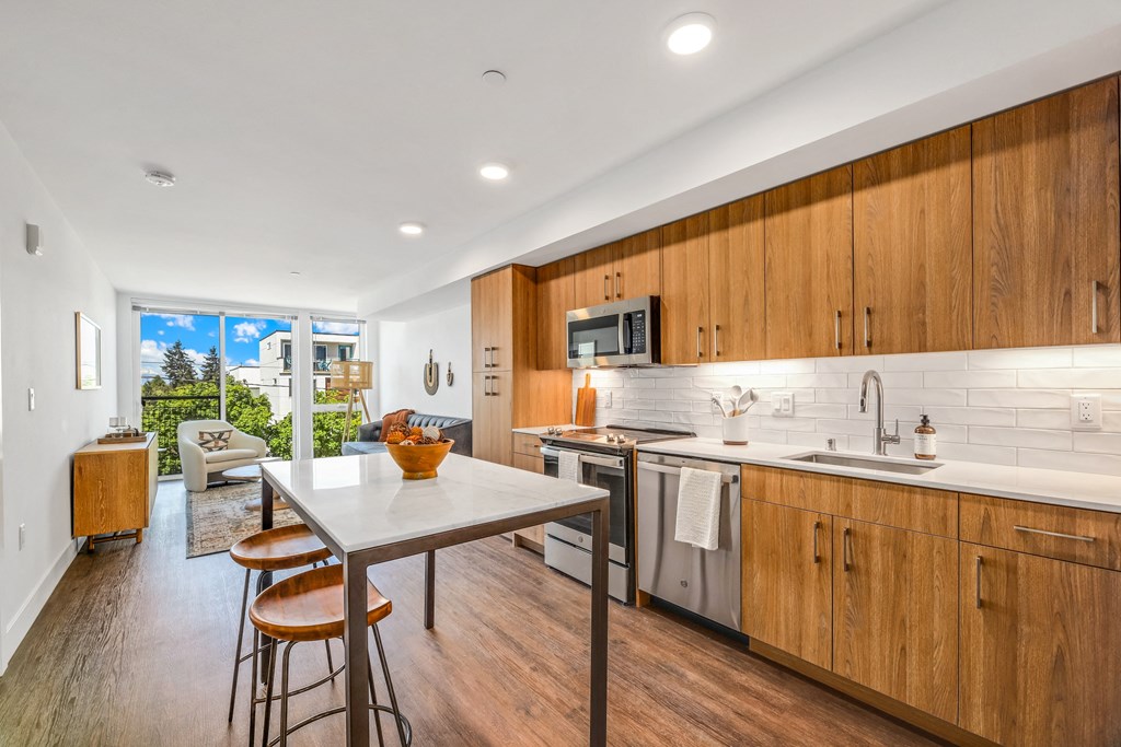 a kitchen with wooden cabinets and a table with three stools
