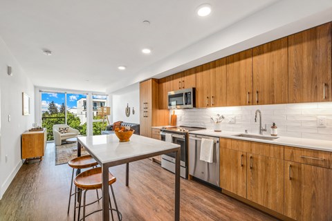 a kitchen with wooden cabinets and a table with three stools