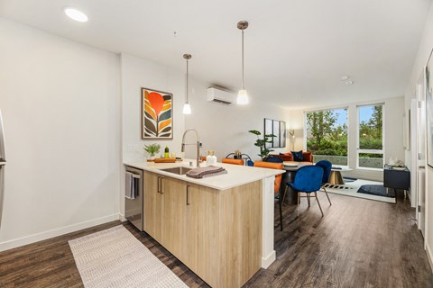 an open kitchen with an island and a living room with a couch